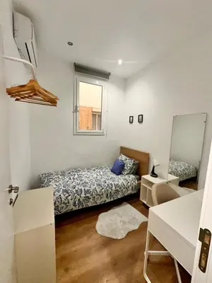 a bedroom with a bed and a desk and a mirror at Habitación 2 Ronda Sant Pau in Barcelona