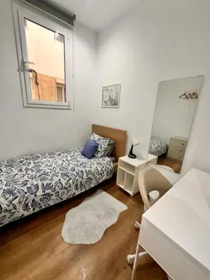 a dining room with white walls and a table and chairs at Habitación 2 Ronda Sant Pau in Barcelona