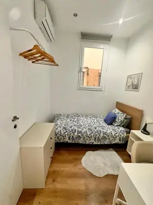 a table and chairs with an umbrella on a roof at Habitación 2 Ronda Sant Pau in Barcelona