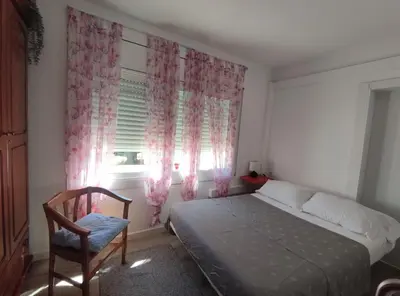 a bedroom with a bed and a chair and a window at Suite de invitados independiente in Cerdanyola del Valles