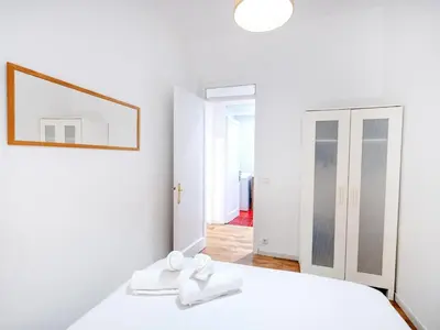 a white bedroom with a bed and a mirror at Apartment amazing Sagrada familia view II in Barcelona