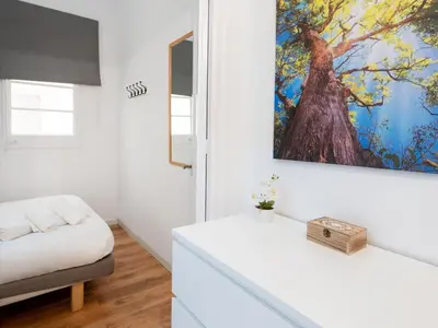 a white living room with a large painting on the wall at Apartment amazing Sagrada familia view II in Barcelona