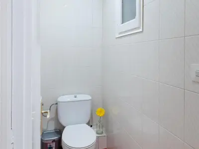 a white bathroom with a toilet and a window at Apartment amazing Sagrada familia view II in Barcelona
