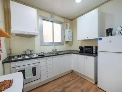 a kitchen with white cabinets and a white refrigerator at Apartment amazing Sagrada familia view II in Barcelona