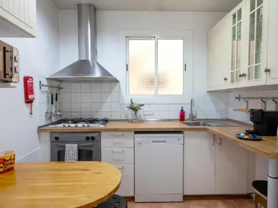 a kitchen with white appliances and a wooden table at Apartment amazing Sagrada familia view I in Barcelona
