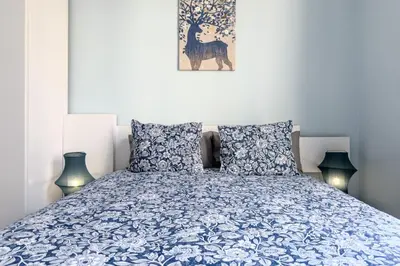 a bedroom with a blue and white bed with two lamps at Habitación 6 con baño junto a Las Ramblas in Barcelona
