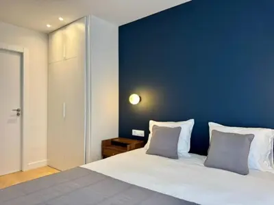 a bedroom with a large bed with a blue wall at Brand new apartment with views in Barcelona in Barcelona