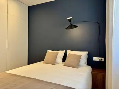 a bedroom with a white bed with a blue wall at Brand new apartment with views in Barcelona in Barcelona