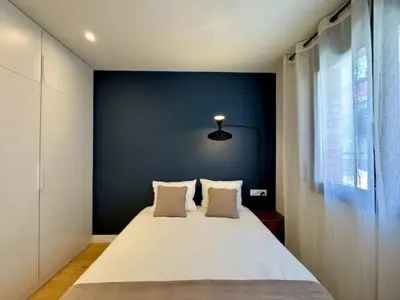 a bedroom with a large bed with a blue wall at Brand new apartment with views in Barcelona in Barcelona