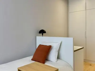 a bedroom with a white bed with a brown pillow at Brand new apartment with views in Barcelona in Barcelona