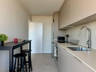 a kitchen with a sink and two bar stools at Brand new apartment with views in Barcelona in Barcelona