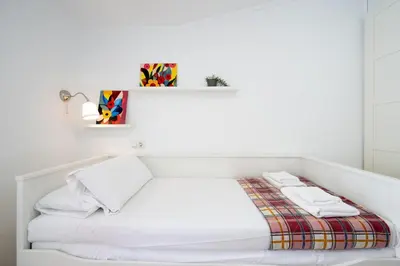 a white bed with two towels on top of it at Apartamento Completo junto playa y Centro Bcn in Badalona