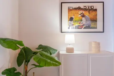 a living room with a picture on the wall and a plant at Apartamento Completo junto playa y Centro Bcn in Badalona