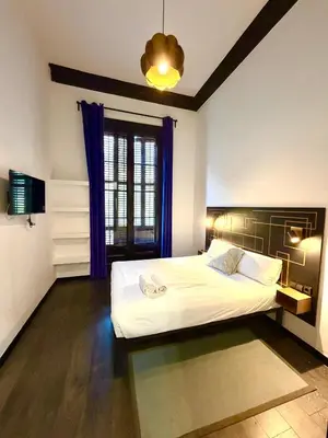 a bedroom with a large white bed with blue curtains at Hotelito Luxe in Barcelona