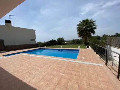 a swimming pool in a backyard with a palm tree at Shambala B&B in Sitges