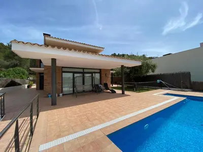 a villa with a swimming pool and a house at Shambala B&B in Sitges