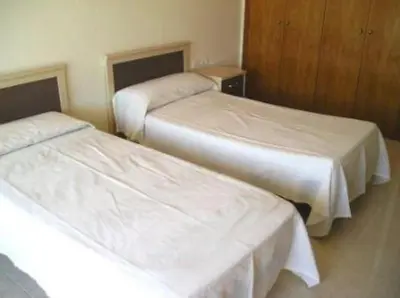 two beds in a hotel room with white sheets at Shambala B&B in Sitges