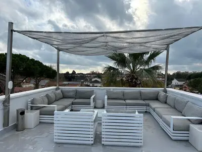a patio with a couch and chairs on a roof at Apartamentos ELMA1 in Castelldefels