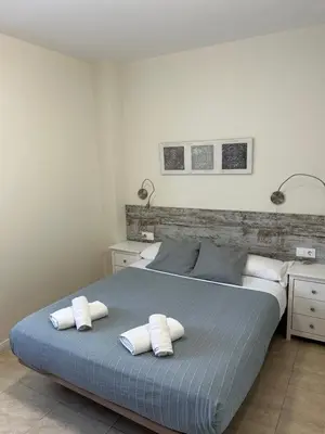 a bedroom with a large bed with two pillows at Apartamentos ELMA1 in Castelldefels
