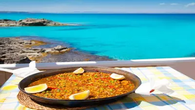 a pan of food on a table next to the ocean at Catalunya Casas Costa Dorada Paradise, 2 km from beach! in Cunit