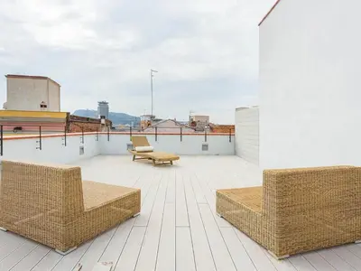 a patio with two chairs and tables on a roof at Guest Ready - Modern apartment by Barcelona Port in Barcelona