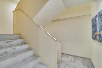a staircase in a white room with a painting at Guest Ready - Modern apartment by Barcelona Port in Barcelona