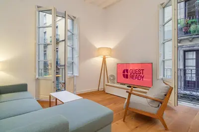a living room with a couch and a sign that reads a guest til mercy at Guest Ready - Modern apartment by Barcelona Port in Barcelona