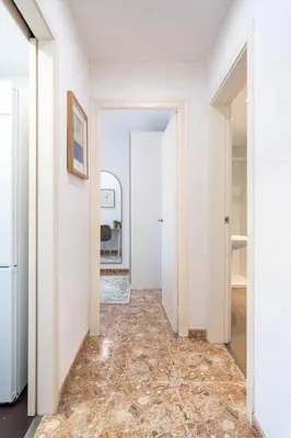a hallway with white walls and a tile floor at Charming 3-Bedroom Flat in the Heart of Les Corts in Barcelona