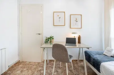 a bedroom with a desk with a laptop and a bed at Charming 3-Bedroom Flat in the Heart of Les Corts in Barcelona