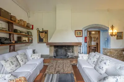 a living room with white couches and a fireplace at Masia Brugarolas in Castelltersol