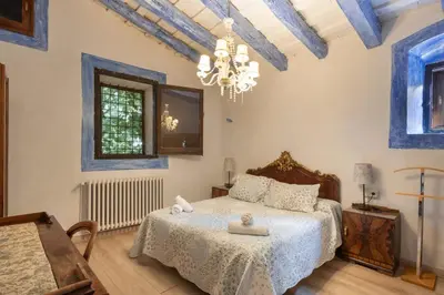 a bedroom with a bed and a chandelier at Masia Brugarolas in Castelltersol