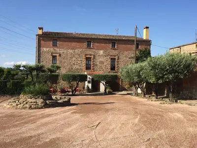 an old brick building with trees in front of it at HOTEL RESTAURANT TURÓ de la TORRE in Manresa