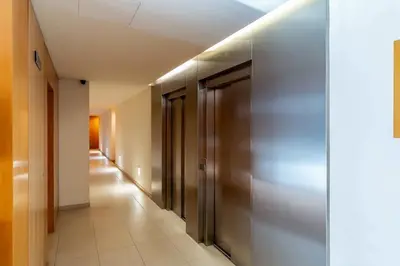 a hallway with metal doors and a tile floor at Canela Homes BARCELONA POBLENOU in Barcelona