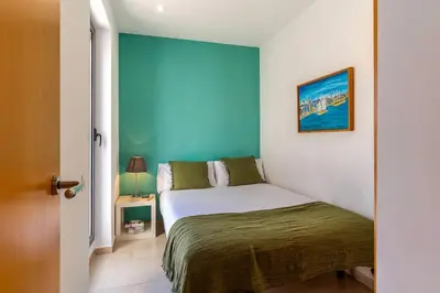a bedroom with a bed with a blue wall at Canela Homes BARCELONA POBLENOU in Barcelona