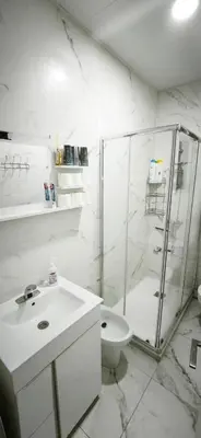 a white bathroom with a shower and a toilet at Playa de Sant Adrià de Besòs in Sant Adria de Besos