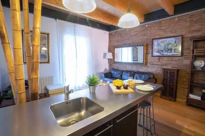 a kitchen with a sink and a living room at Barcelona - Loft Paseo de gracia in Barcelona