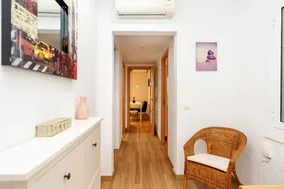 a kitchen with white walls and a wooden floor at Apartamento Comte Borrell in Barcelona