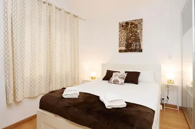 a bedroom with a white bed with two towels on it at Apartamento Comte Borrell in Barcelona