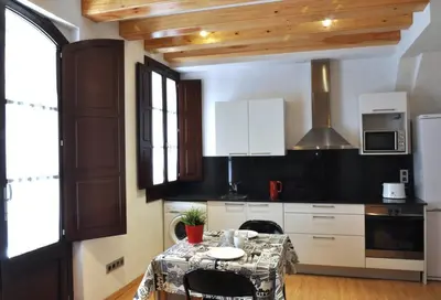 a kitchen with white cabinets and a table at Barceloneta Beach 2 in Barcelona