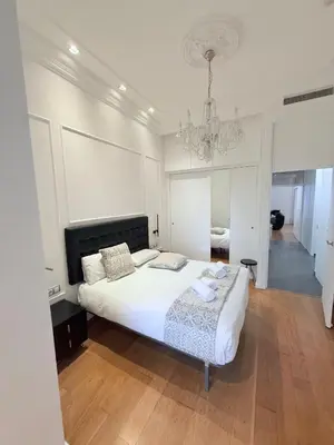 a bedroom with a large bed and a chandelier at CENTRAL CITY Ivax in Barcelona