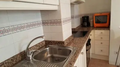 a kitchen with a sink and a microwave at Estrella Primero De Mayo in Sitges