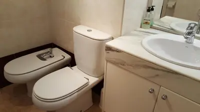 a bathroom with a white toilet and a sink at Estrella Primero De Mayo in Sitges