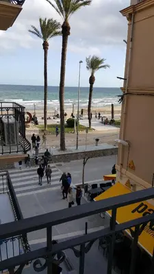 a group of people walking down the stairs near the beach at Estrella Primero De Mayo in Sitges