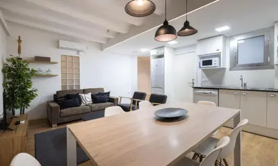 a kitchen and a living room with a table and chairs at Stay U-nique Sant Pau in Barcelona