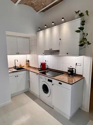 a kitchen with white cabinets and a washing machine at Cozy Barceloneta Beach Flat - Newly Renovated in Barcelona