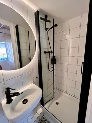 a white bathroom with a sink and a shower at Cozy Barceloneta Beach Flat - Newly Renovated in Barcelona