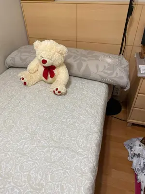 a teddy bear sitting on top of a bed at Casa Lara in Barcelona