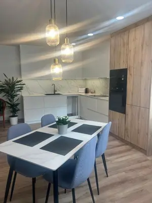 a kitchen with a white table and blue chairs at Villa Montjuic Apartments in Barcelona