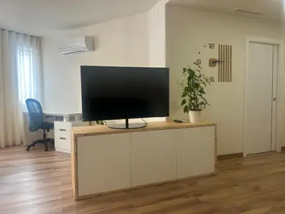 a flat screen tv sitting on top of a wooden cabinet at Villa Montjuic Apartments in Barcelona