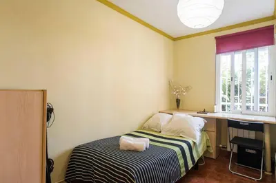 a bedroom with a bed and a desk and a window at Best sea views, 20 minutes to Barcelona in Montgat
